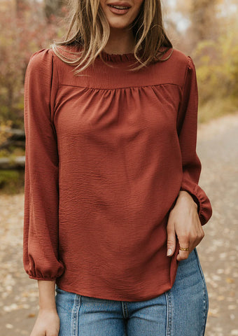 rust colored ruffled blouse. www.loveoliveco.com