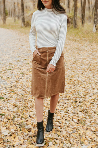 corduroy skirt paired with a black and white striped turtleneck. www.loveoliveco.com