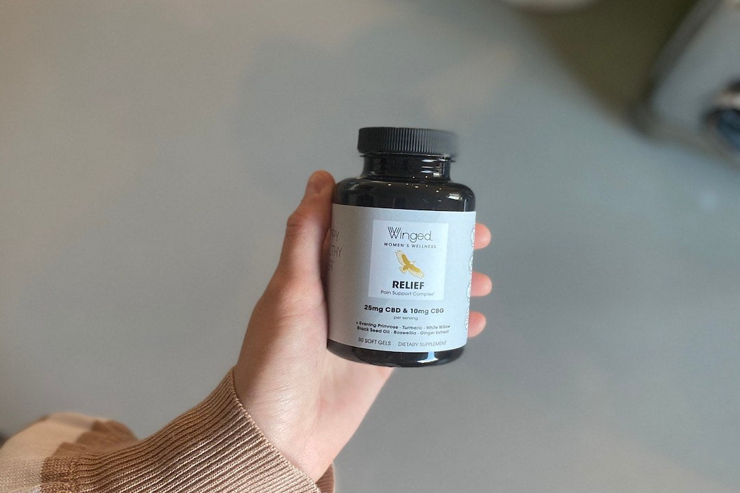 Winged Wellness bottle in a hand