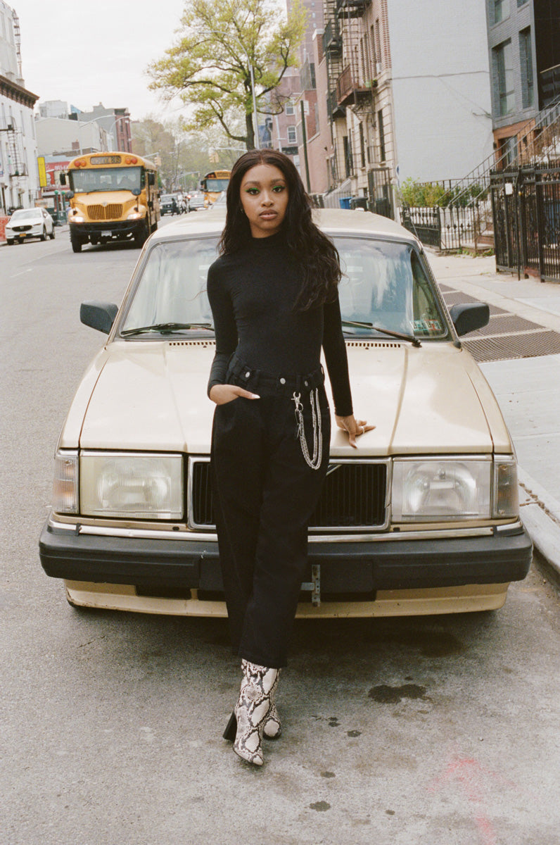 Andrea Vallé leaning in front of an older car in New York