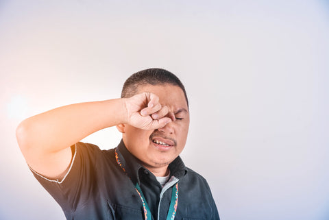 asian man rubbing his eyes because they are dry