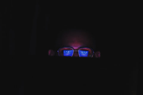blue light reflected on a person's spectacles