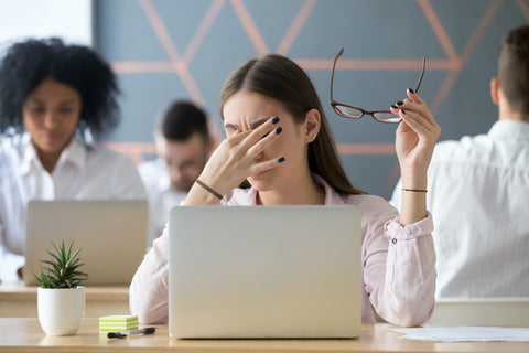 A girl with eye strain at her computer.