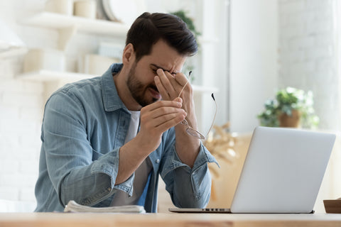 A man with eye strain at his computer.