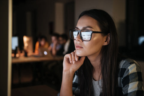 A girl with glasses on her computer.