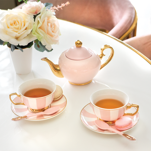 pink tea pot and tea set with herbal tea brewed