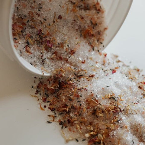 bath salts with dried flowers poured out of container