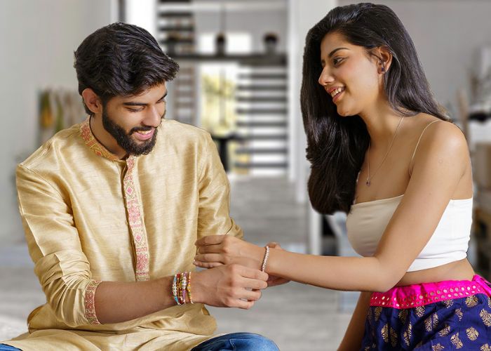 Brother tying a bracelets to his sister's wrist