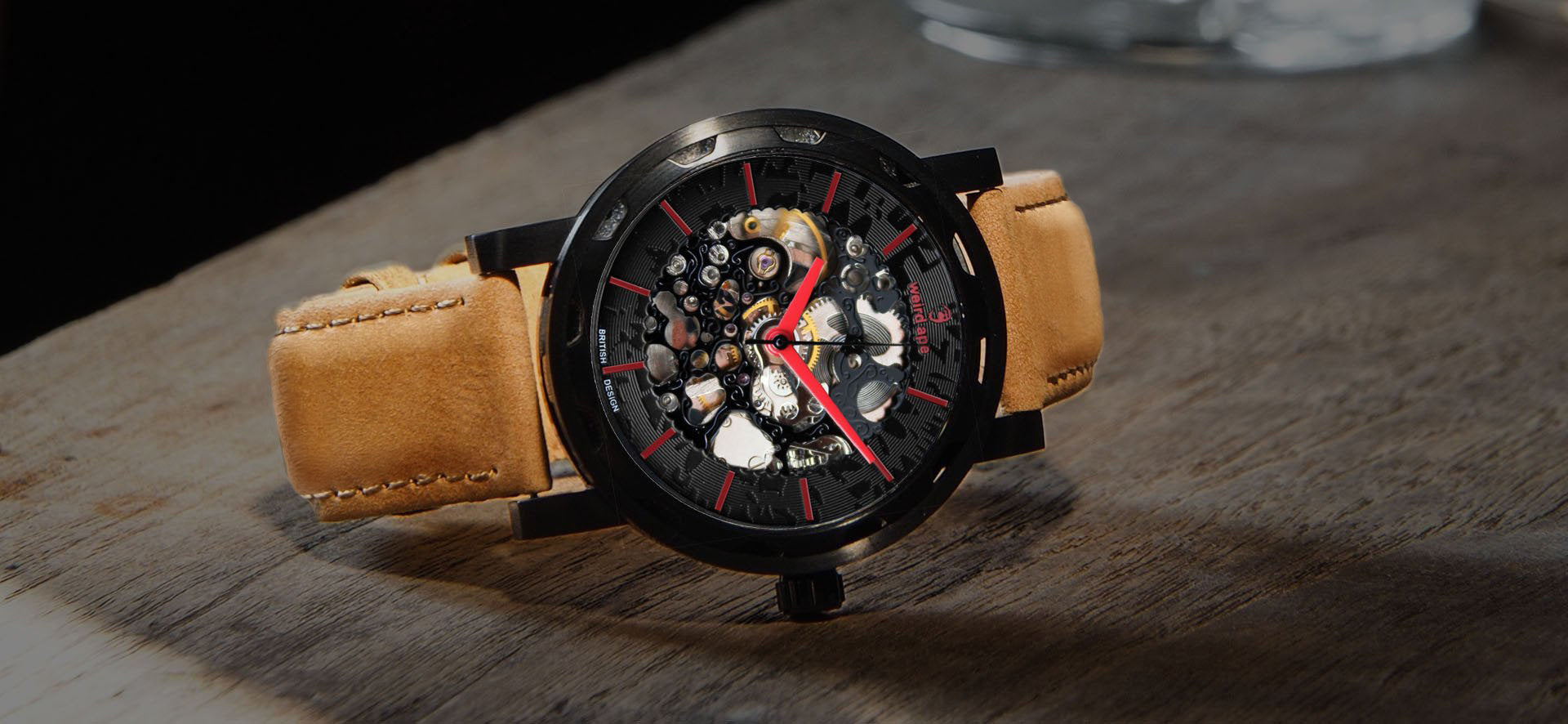 Black skeleton watch with a tan strap in a lifestyle image