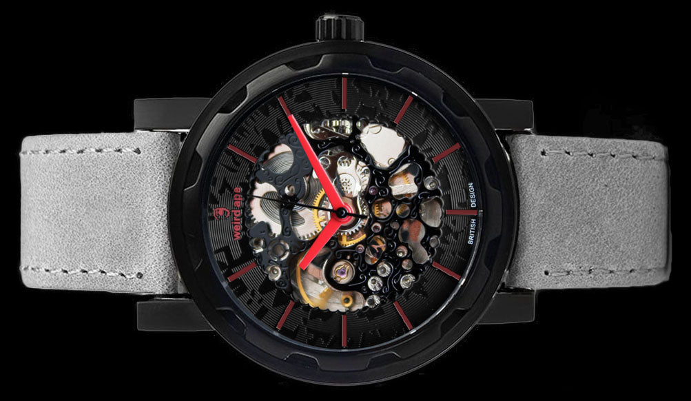 Black mechanical watch with grey strap on its side.