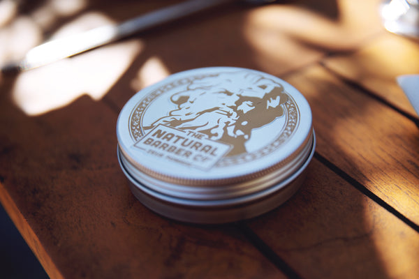 Tin of Zeus Pomade on a table