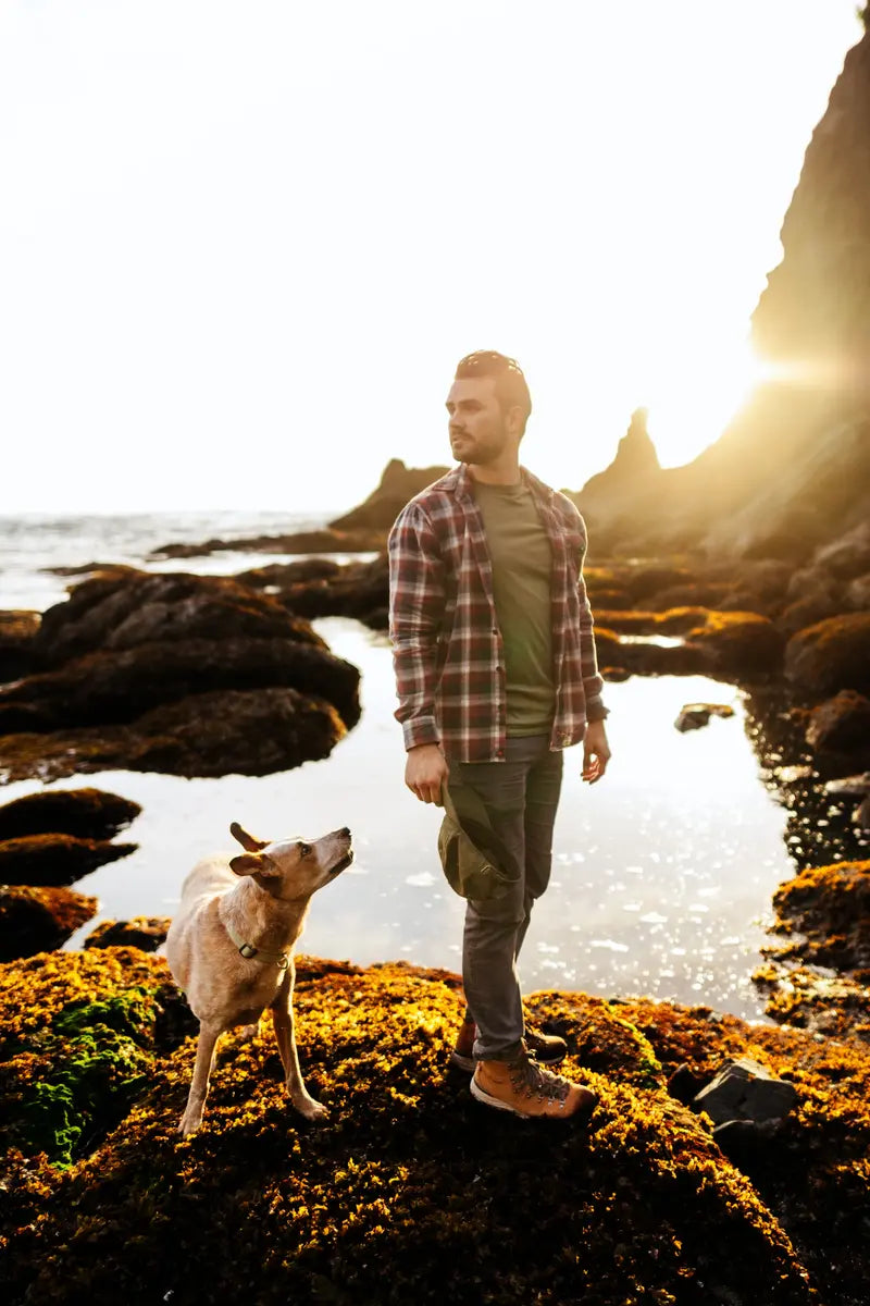 man looking over his shoulder standing next to a dog posing for a picture