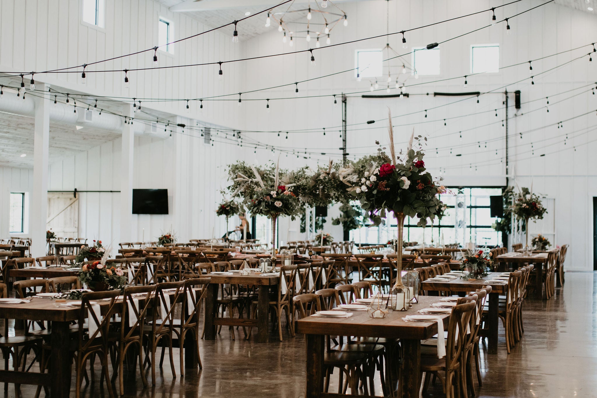 Stunning boho chic wedding at the Pines White in Davenport, North Dakota featuring a lounge curated by Gathered Rentals and Events, a hanging installation filled with dried palms and pampas grass, and beautiful bouquets of eucalyptus, tulips, roses, dried elements, and peonies.