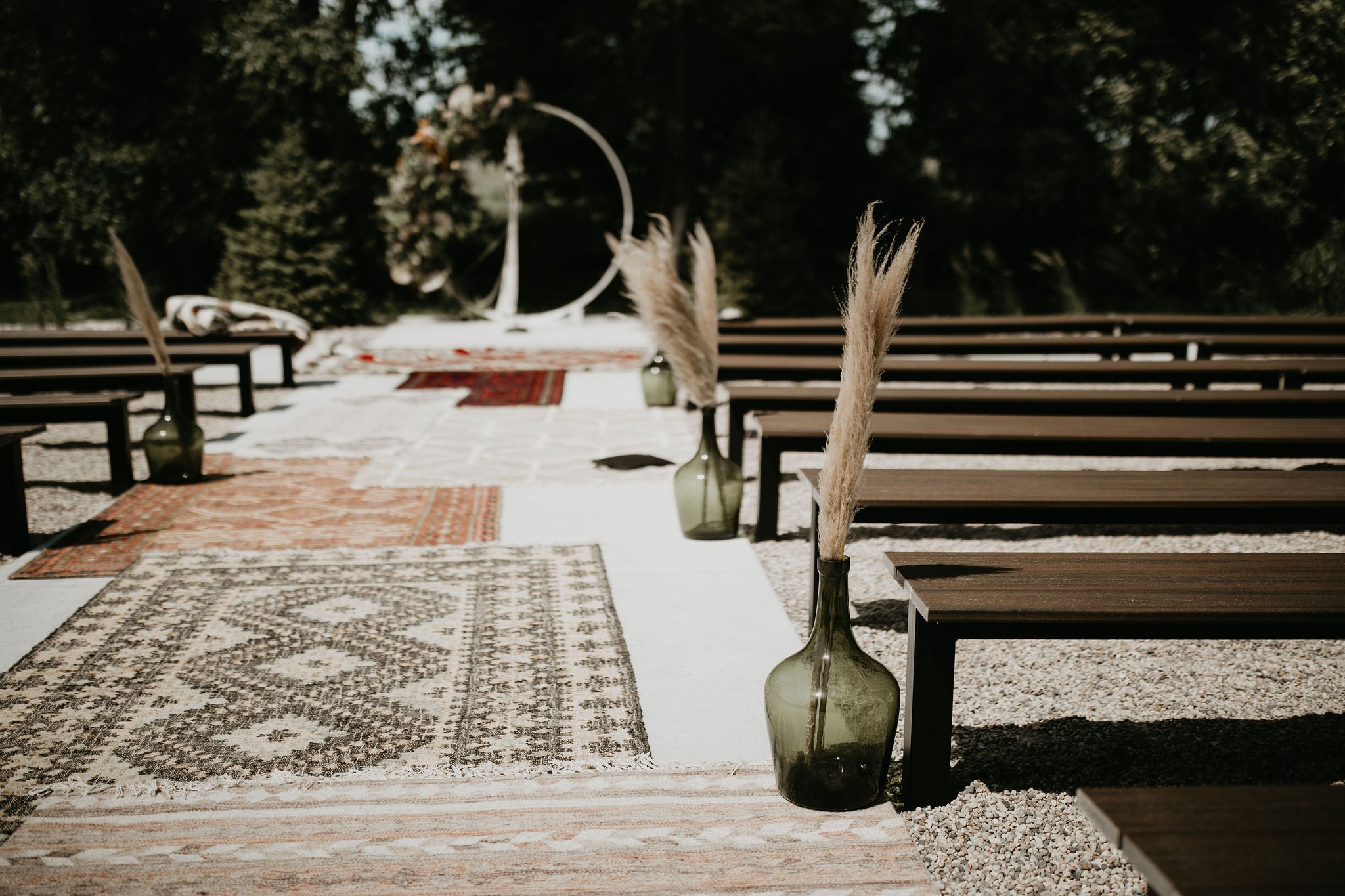 Stunning boho chic wedding at the Pines White in Davenport, North Dakota featuring a lounge curated by Gathered Rentals and Events, a hanging installation filled with dried palms and pampas grass, and beautiful bouquets of eucalyptus, tulips, roses, dried elements, and peonies.