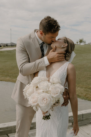 Wedding celebration at Oxbow Country Club in North Dakota with white garden roses, elegant floral installations, and stunning photography by Revelwood Photography