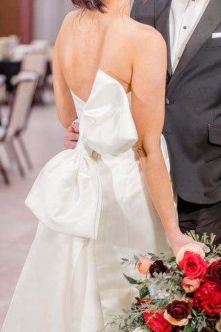 Jewel-toned wedding bouquet featuring peonies, garden roses, ranunculus, winter greenery and peach accents, in Fargo, ND