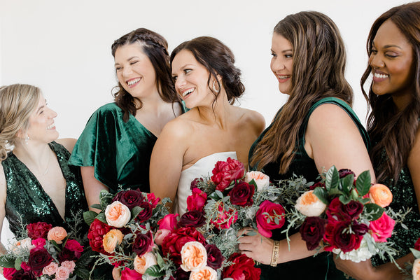 Evergreen bridesmaids dresses complementing the bold jewel-toned florals at a winter wedding in Fargo, ND
