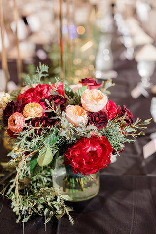 Jewel-toned wedding bouquet featuring peonies, garden roses, ranunculus, winter greenery and peach accents, in Fargo, ND