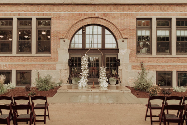 Exquisite floral arch of white roses and delicate babies breath sets the stage for a beautiful Fargo wedding ceremony - crafted by Floret and Foliage, the premier wedding florist.