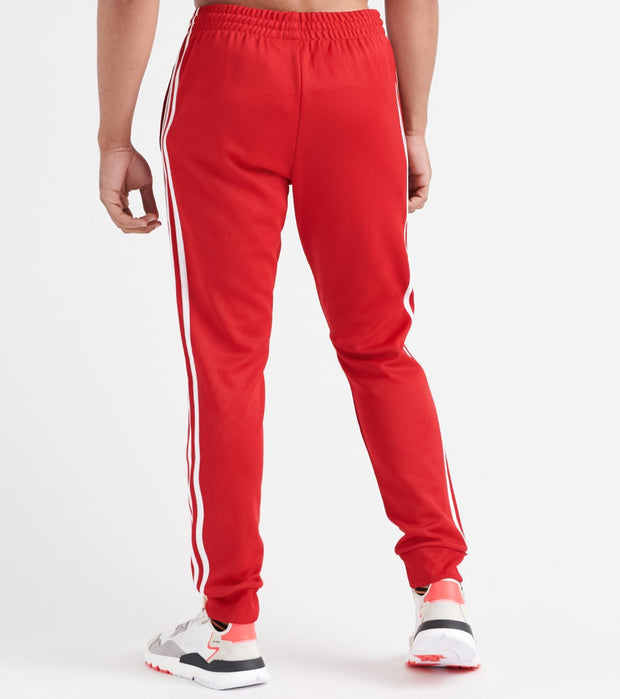 black adidas track pants with red stripes
