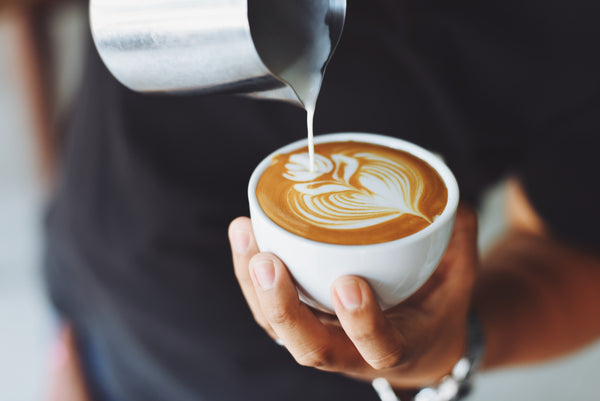 person pouring coffee into a mug