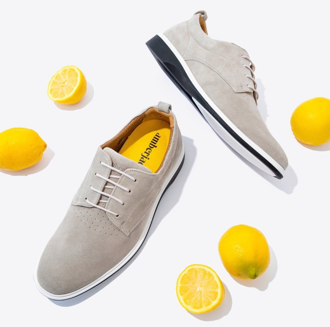 The Original suede shoes in slate are displayed next to lemons.