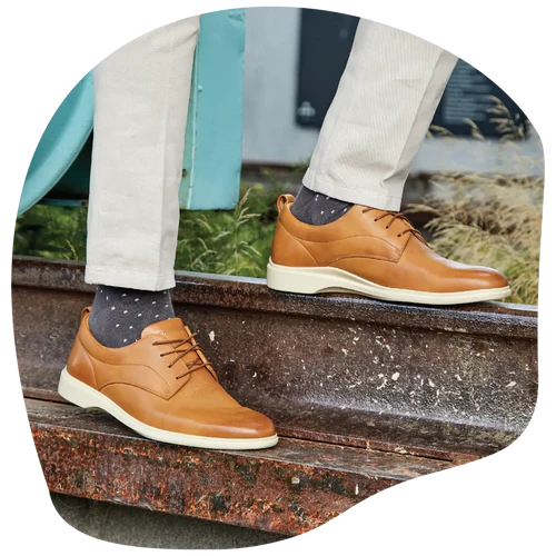 A man standing on a bench in his Amberjack Honey & Cream tan dress shoes for men