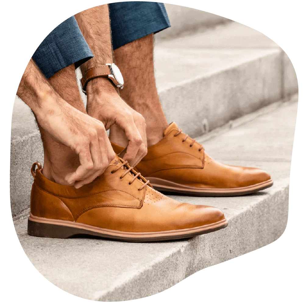 A man adjusting his Original dress shoes from Amberjack in the color honey