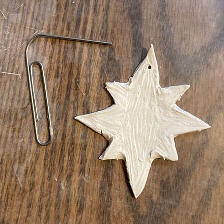 Homeschool science craft project making star shaped ornament of clay with hole for ribbon