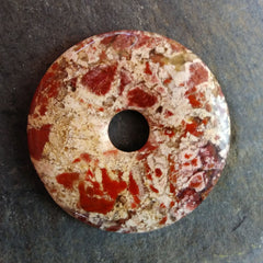 Brecciated jasper stone donut mostly cream with bits of rusty red