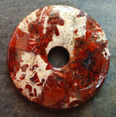 Brecciated jasper stone donut mostly red with a swath of cream