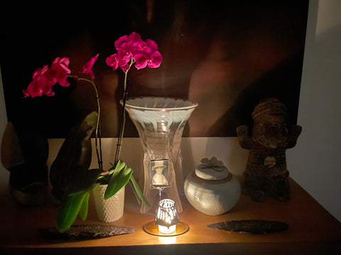 table with urn, yahrzeit candle, purple orchid, artwork