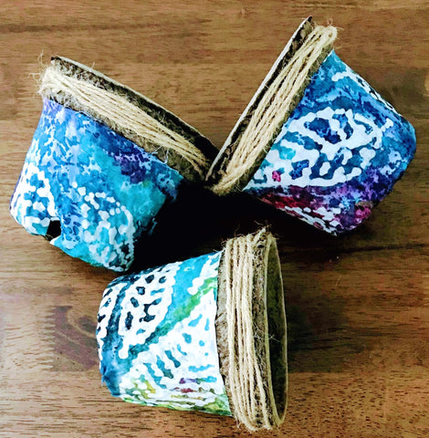 Four inch plant pots covered in decorative fabric with colorful leaf pattern. Click link to visit shop and purchase pots or other eco-friendly gardening supplies.