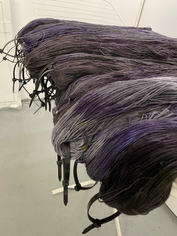 Carmilla gray and purple yarn drying in a basement