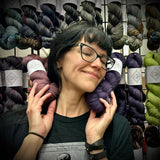 Rita of Ex Libris Fibers snuggles some yarn skeins