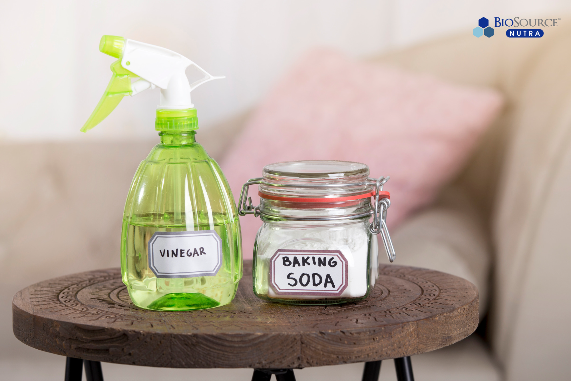A spray bottle of vinegar and a glass jar of baking soda