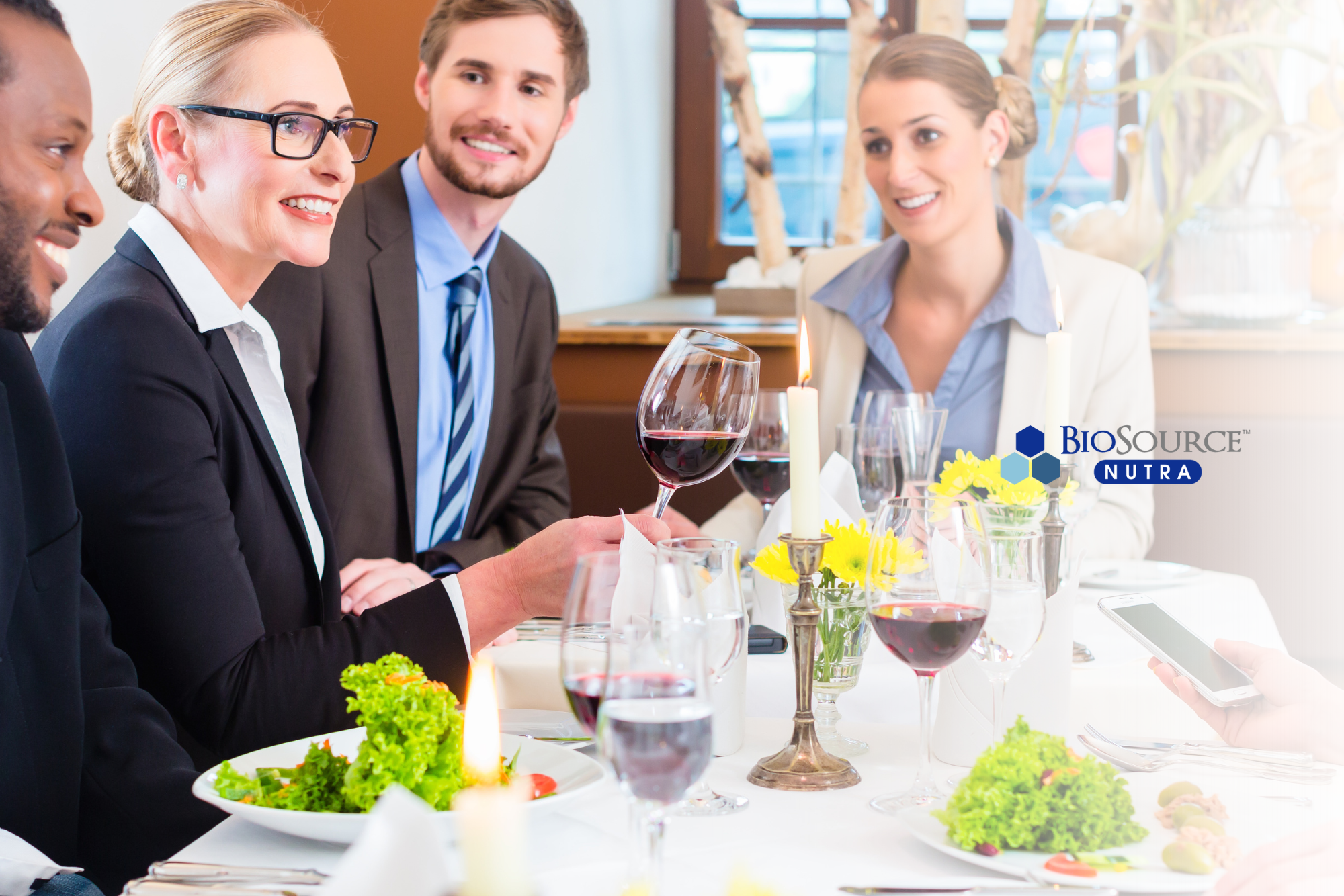 A group of young professionals dine together at a restaurant