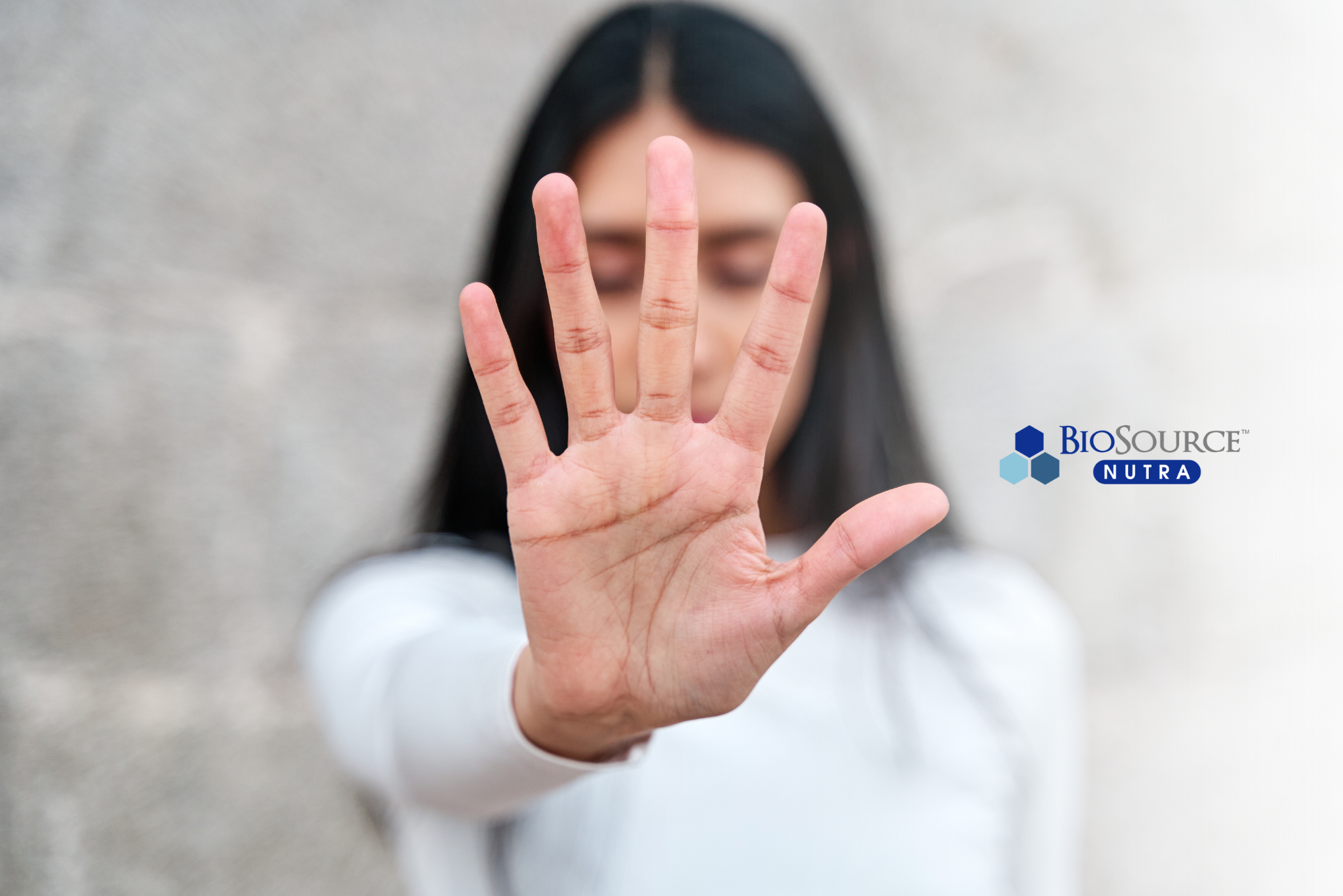 A young woman holds up her hand to say "no"