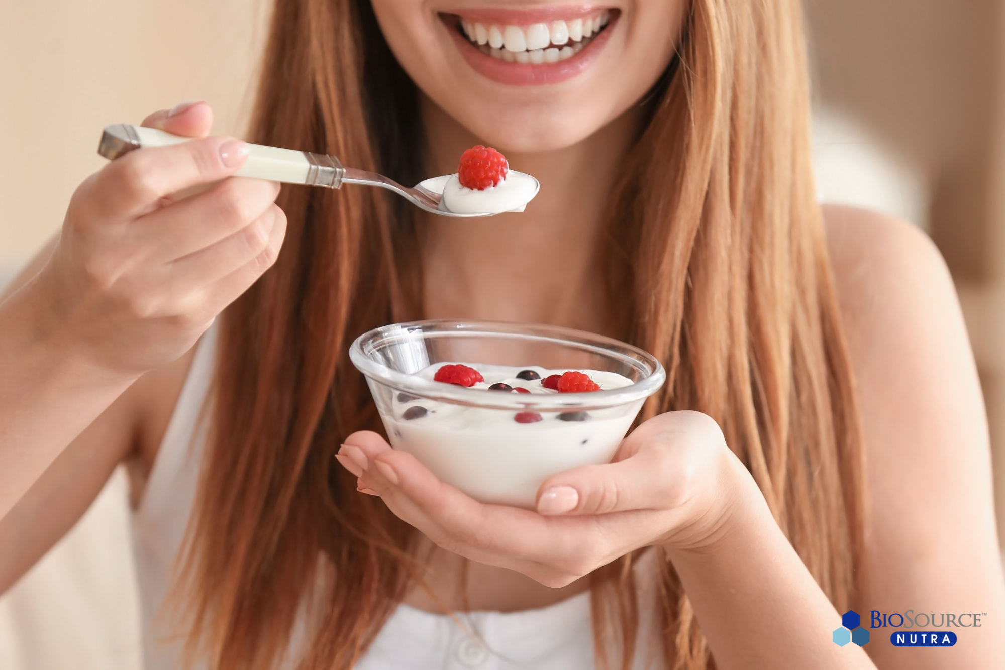 A young woman eats a bowl of yogurt and fruit