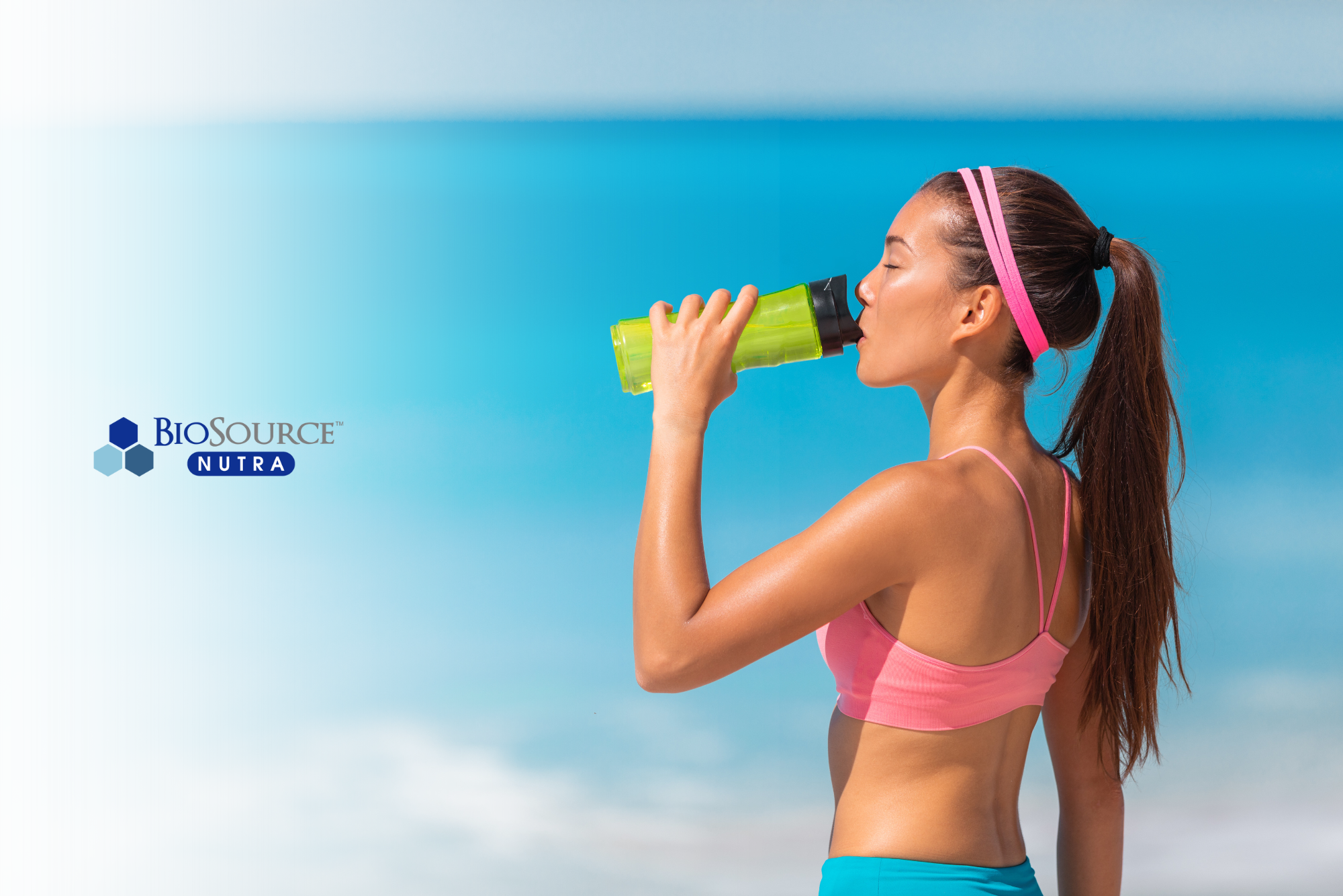 A young woman drinks water after she enjoys a run