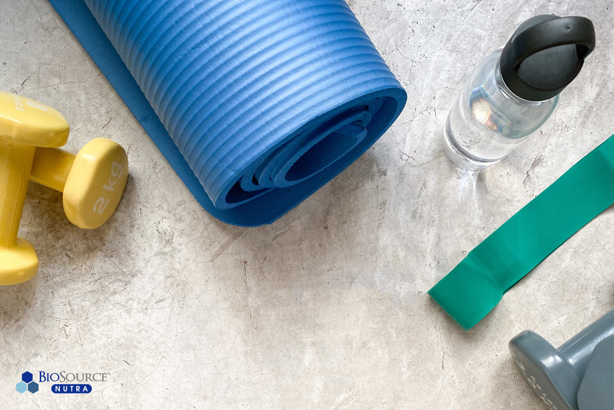 A set of weights, a yoga mat, a water bottle, and resistance bands