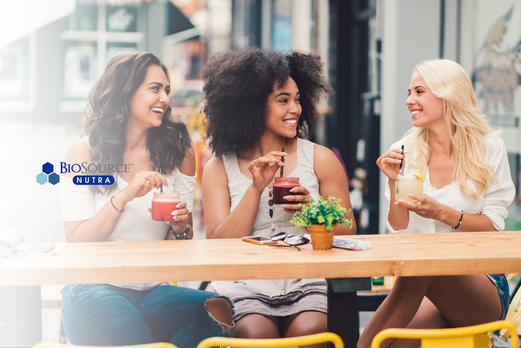 Three young women enjoy smoothies together as a treat