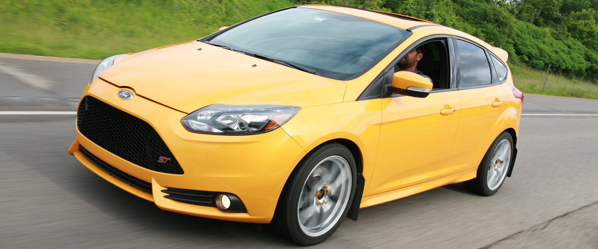 yellow car driving on the road