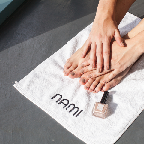 hands and feet with the nami nude nail polish applied