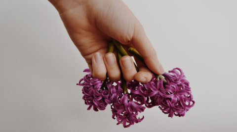 Unpolished hands holding a flower