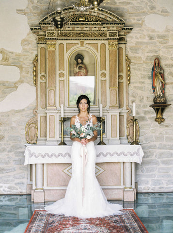 Bride holding wedding bouquet with trailing pink silk ribbons