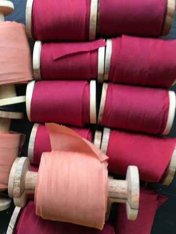 Burgundy silk ribbons on wooden spool