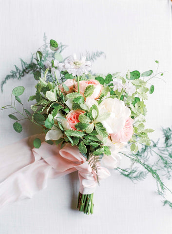 Pink and white flowers in bridl bouquet tied with plant dyed silk ribbons
