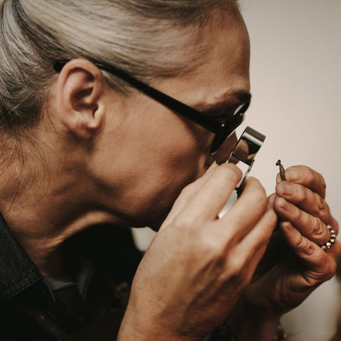 Jeweler looking at ring with magnifier