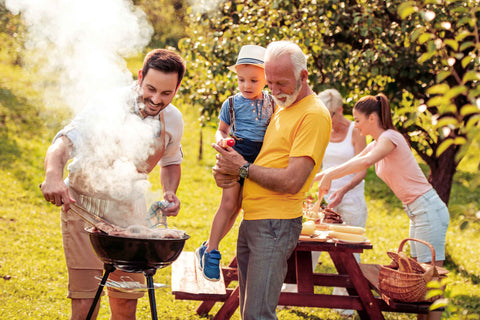 Männer mit Familie am Grill